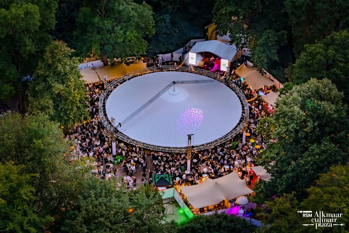 Bezoekers op een evenement met verlicht podium, verzekerd via een evenementenverzekering