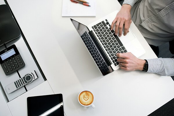Directeur aan het werk achter een laptop, met een AOV voor de dga