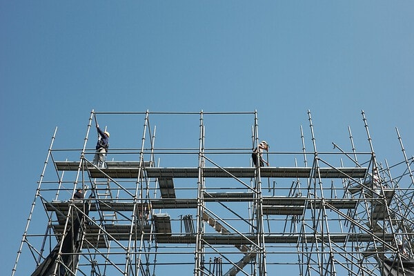 Bouwvakkers op een steiger, ingehuurde zzp'ers op een bouwproject